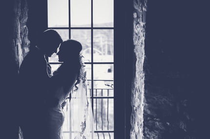 picture of a bride and groom in and older looking enclave near a window having a quiet moment after their wedding