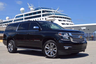 black SUV sitting on the parking area at the port near a cruise ship